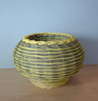a yellow wicker basket on a wooden table